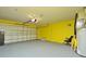 Spacious garage with yellow painted walls, automatic door and concrete floors at 847 Orista Dr, Davenport, FL 33897