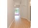 Bright hallway with hardwood floors that leads to a room with a sliding glass door and pool view at 847 Orista Dr, Davenport, FL 33897