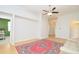 Open-concept living room with a ceiling fan, neutral paint, and a bright red area rug on hardwood floors at 847 Orista Dr, Davenport, FL 33897