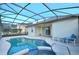 Screened-in pool and spa with adjacent seating area and views of neighboring houses at 847 Orista Dr, Davenport, FL 33897