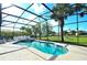 Inviting screened-in pool and spa overlooking the green lawn with blue skies at 847 Orista Dr, Davenport, FL 33897