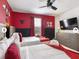 Playful bedroom featuring two beds, red accent walls, and fun decor in a clean space at 9118 Sommerset Hills Dr, Davenport, FL 33896