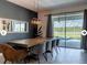 Modern dining room with a long wooden table and chairs with sliding glass doors to backyard pool at 9118 Sommerset Hills Dr, Davenport, FL 33896