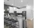 Modern kitchen featuring white cabinets, a breakfast bar with seating, and stainless steel appliances at 9118 Sommerset Hills Dr, Davenport, FL 33896
