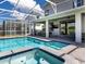 A sparkling pool features an attached spa and spacious seating areas for relaxing and entertaining outdoors at 9118 Sommerset Hills Dr, Davenport, FL 33896