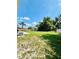 A spacious backyard featuring a lush green lawn and mature trees, perfect for outdoor activities at 467 Martigues Drive, Kissimmee, FL 34759