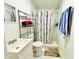 Modern bathroom with marble-look shower, black-and-white shower curtain, and chrome storage at 467 Martigues Drive, Kissimmee, FL 34759