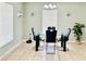 Dining room features a glass table, black chairs, bright lighting, and a sleek, modern design at 467 Martigues Drive, Kissimmee, FL 34759