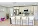 Bright kitchen featuring stainless steel appliances, white cabinetry, and a large island with bar seating at 467 Martigues Drive, Kissimmee, FL 34759