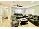 Comfortable living room with tile flooring, ceiling fan, and cozy black leather reclining sofas at 467 Martigues Drive, Kissimmee, FL 34759