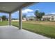 A covered lanai looks out to a spacious backyard with green grass and neighboring homes in a peaceful setting at 1027 Cloud Ridge Ct, Mount Dora, FL 32757