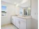 Bright bathroom featuring double sinks, quartz countertops, and a large mirror at 1027 Cloud Ridge Ct, Mount Dora, FL 32757