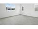 Bright, empty bedroom showcasing large windows and neutral gray tile flooring at 1027 Cloud Ridge Ct, Mount Dora, FL 32757