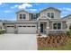 Beautiful two-story gray home featuring a spacious three-car garage and attractive landscaping at 1027 Cloud Ridge Ct, Mount Dora, FL 32757