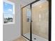 Modern bathroom featuring a tiled shower with a glass door and window, showcasing a bright and clean space at 1035 Cloud Ridge Ct, Mount Dora, FL 32757