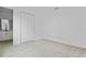 A clean bedroom featuring neutral carpet, a double door closet, and a partial view of an ensuite bathroom at 1035 Cloud Ridge Ct, Mount Dora, FL 32757