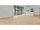 Open-concept living room with wood-look tile flooring, seamlessly connected to a modern kitchen and outdoor patio at 1035 Cloud Ridge Ct, Mount Dora, FL 32757