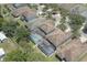 Aerial view of multiple homes showcasing screened pools, green lawns, and mature trees at 1043 Tourmaline Dr, Kissimmee, FL 34746