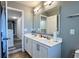 Bathroom with a double sink vanity, a large mirror, and modern fixtures over tile floors at 1043 Tourmaline Dr, Kissimmee, FL 34746