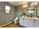 Neutral bathroom featuring a double sink vanity with a framed mirror and updated fixtures at 1043 Tourmaline Dr, Kissimmee, FL 34746