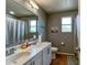 Bathroom with double vanity sinks, tile flooring, and a shower with curtain next to two windows at 1043 Tourmaline Dr, Kissimmee, FL 34746