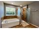 Bathroom features a tiled shower, a soaking tub, and a window for natural light at 1043 Tourmaline Dr, Kissimmee, FL 34746