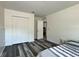 Clean bedroom with grey plank floors and double door closets, offering modern comfort at 1043 Tourmaline Dr, Kissimmee, FL 34746