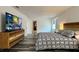 Spacious bedroom features a large TV, modern dresser, light from the window, and comfortable bed at 1043 Tourmaline Dr, Kissimmee, FL 34746