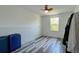 Minimalist bedroom featuring a colorful ceiling fan, light wood plank flooring, and a bright window view at 1043 Tourmaline Dr, Kissimmee, FL 34746
