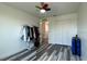 Clean bedroom featuring wood look floors, a colorful ceiling fan, and a double door closet at 1043 Tourmaline Dr, Kissimmee, FL 34746