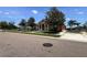 Exterior of a well-manicured clubhouse featuring a terracotta roof and a beautifully landscaped lawn at 1043 Tourmaline Dr, Kissimmee, FL 34746