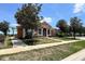 Beautiful clubhouse with mature landscaping, lush green lawn, and a terracotta-colored roof at 1043 Tourmaline Dr, Kissimmee, FL 34746