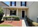 Inviting front porch with manicured hedges, dark shutters, and a welcoming entrance with a black front door at 1043 Tourmaline Dr, Kissimmee, FL 34746