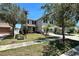 Two-story home with palm trees and well-kept front lawn with professional landscaping at 1043 Tourmaline Dr, Kissimmee, FL 34746