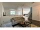 Open-concept living room featuring modern furniture, neutral decor, and seamless flow into the kitchen and dining area at 1043 Tourmaline Dr, Kissimmee, FL 34746