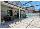 Spacious screened-in patio with a dining table, outdoor kitchen, and comfortable seating, perfect for relaxation at 1043 Tourmaline Dr, Kissimmee, FL 34746
