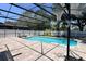 A screened in pool with pavers surrounding it, plus lounge chairs and a basketball net for outdoor fun at 1043 Tourmaline Dr, Kissimmee, FL 34746