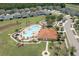 Aerial view of a community pool with lounge chairs surrounded by lush greenery and a clubhouse at 1043 Tourmaline Dr, Kissimmee, FL 34746