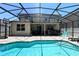 A refreshing private screened-in swimming pool with brick-paved patio and outdoor kitchen and lounge area at 1043 Tourmaline Dr, Kissimmee, FL 34746