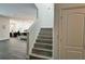 Stylish staircase featuring grey wood-look floors, leading to the upper level, with a glimpse of the modern kitchen at 1043 Tourmaline Dr, Kissimmee, FL 34746