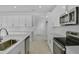 Bright kitchen featuring stainless steel appliances, white cabinets, ample counter space, and tile floors at 1051 Cloud Ridge Ct, Mount Dora, FL 32757