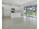A bright kitchen with white cabinets, stainless steel appliances, a kitchen island, and sliding glass doors to the yard at 1051 Cloud Ridge Ct, Mount Dora, FL 32757
