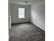 Bright bedroom with plush carpeting, fresh paint, and a sunny window, offers a serene and comfortable space at 1053 Waterfall Blvd, Davenport, FL 33837