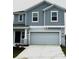 Charming two-story home with a gray exterior, a two-car garage, and a well-maintained front yard at 1053 Waterfall Blvd, Davenport, FL 33837