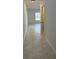 Bright hallway with neutral tile flooring leading to a room with a large window at 1053 Waterfall Blvd, Davenport, FL 33837