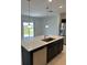 Kitchen island featuring a stainless steel sink, dishwasher, and pendant lighting at 1053 Waterfall Blvd, Davenport, FL 33837