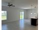 Open-concept living room with tile floors, a ceiling fan, and sliding glass doors at 1053 Waterfall Blvd, Davenport, FL 33837