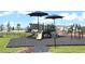 Community playground featuring slides, swings, and shaded seating area, providing a fun and safe recreational space for residents at 1053 Waterfall Blvd, Davenport, FL 33837