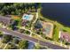 Aerial view featuring community pool, tennis court, and lush landscaping near a serene lake at 10733 Savannah Landing Cir, Orlando, FL 32832