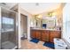 Bathroom with double sink vanity with a large mirror and walk in shower with a glass door at 10733 Savannah Landing Cir, Orlando, FL 32832